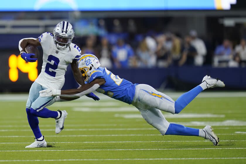 Dallas Cowboys' KaVontae Turpin (2), left, runs past Los Angeles Chargers safety JT Woods (22) during the first half of a preseason NFL football game Saturday, Aug. 20, 2022, in Inglewood, Calif. (AP Photo/Gregory Bull)