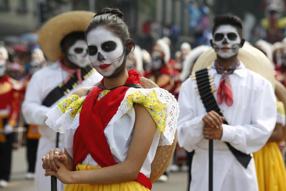 Performers in costume attend a Day of the Dead parade in Mexico City, Sunday, Oct. 27, 2019. The parade on Sunday marks the fourth consecutive year that the city has borrowed props from the opening scene of the James Bond film, “Spectre,” in which Daniel Craig’s title character dons a skull mask as he makes his way through a crowd of revelers. (AP Photo/Ginnette Riquelme)