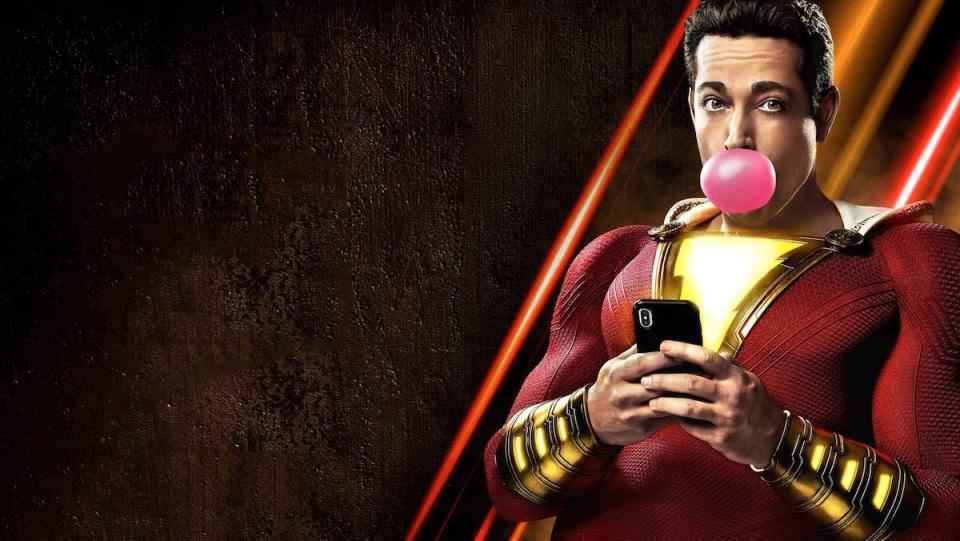 Shazam blowing a bubble and looking at a phone