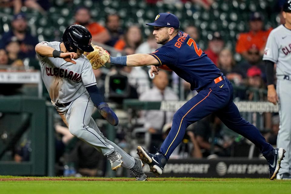 Cleveland Guardians' Steven Kwan, left, is tagged out by Houston Astros third baseman Alex Bregman (2) during the eighth inning of a baseball game Monday, May 23, 2022, in Houston. (AP Photo/David J. Phillip)