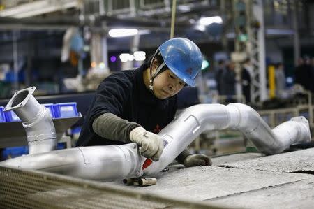 A man works at the assembly line of the Mitsubishi Fuso Truck and Bus Corporation (MFTBC) factory in Kawazaki, south of Tokyo March 10, 2015. REUTERS/Thomas Peter