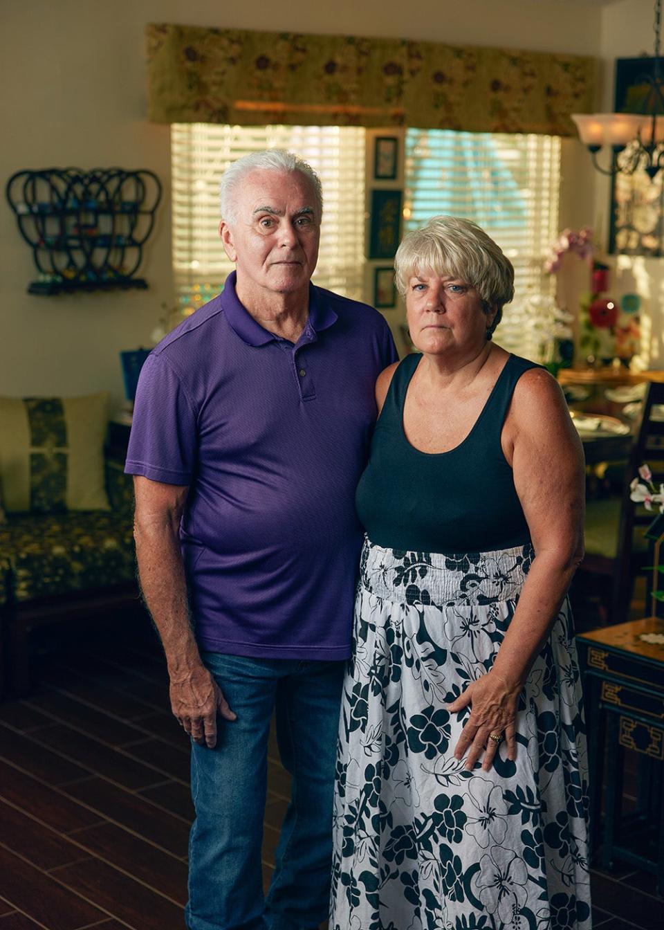 George and Cindy Anthony standing next to each other and looking serious in a low lit room