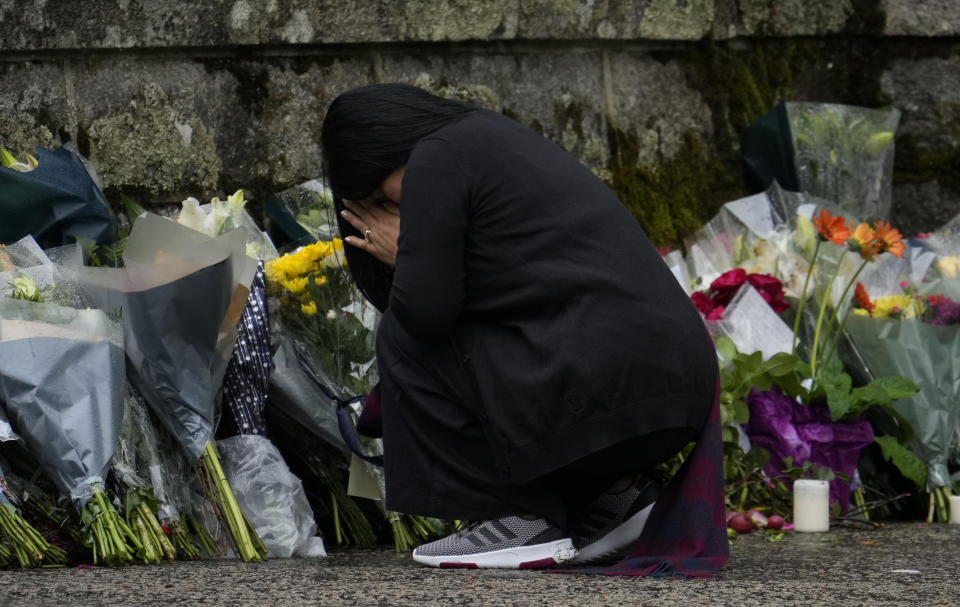 Una mujer reacciona tras dejar una ofrenda floral fuera de las puertas del Castillo de Balmoral en Aberdeenshire, Escocia, el 9 de septiembre de 2022. La reina Isabel II, la monarca con el reinado más largo de Gran Bretaña, falleció en Balmoral el 8 de septiembre a los 96 años. (Foto AP/Alastair Grant)