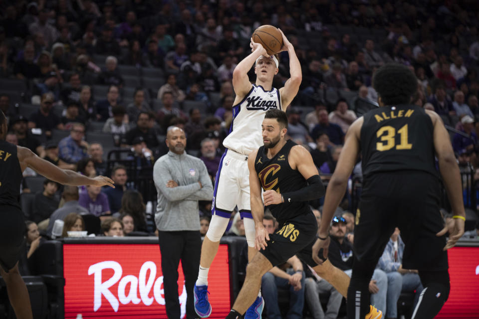 Sacramento Kings guard Kevin Huerter, center, puts up a three point shot as Cleveland Cavaliers guard Max Strus, center right, defends in the second half in an NBA basketball game in Sacramento, Calif., Monday, Nov. 13, 2023. (AP Photo/José Luis Villegas)