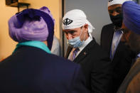 Sen. Todd Young, R-Ind., speaks with members of the Sikh Coalition at the Sikh Satsang of Indianapolis in Indianapolis, Saturday, April 17, 2021, for a commemoration of the victims of the shooting at a FedEx facility in Indianapolis that claimed the lives of four members of the Sikh community. A gunman killed eight people and wounded several others before taking his own life in a late-night attack at a FedEx facility near the Indianapolis airport. (AP Photo/AJ Mast)