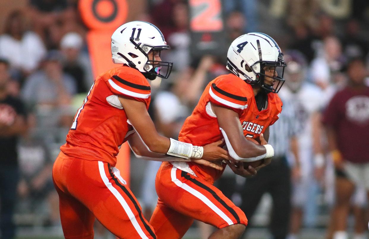 Beaver Falls Jaren Brickner (11) hands the ball off to Isaiah Aeschbacher (4) during the first half against the Beaver Bobcats Friday night at Reeves Stadium in Beaver Falls.