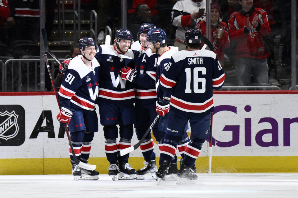 Washington Capitals defenseman Rasmus Sandin (38) celebrates after his goal with center Joe Snively (91), center Craig Smith (16) and others during the first period of an NHL hockey game against the New York Islanders, Monday, April 10, 2023, in Washington. (AP Photo/Nick Wass)