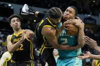 Golden State Warriors guard Moses Moody fouls Charlotte Hornets forward Grant Williams during the second half of an NBA basketball game on Friday, March 29, 2024, in Charlotte, N.C. (AP Photo/Chris Carlson)