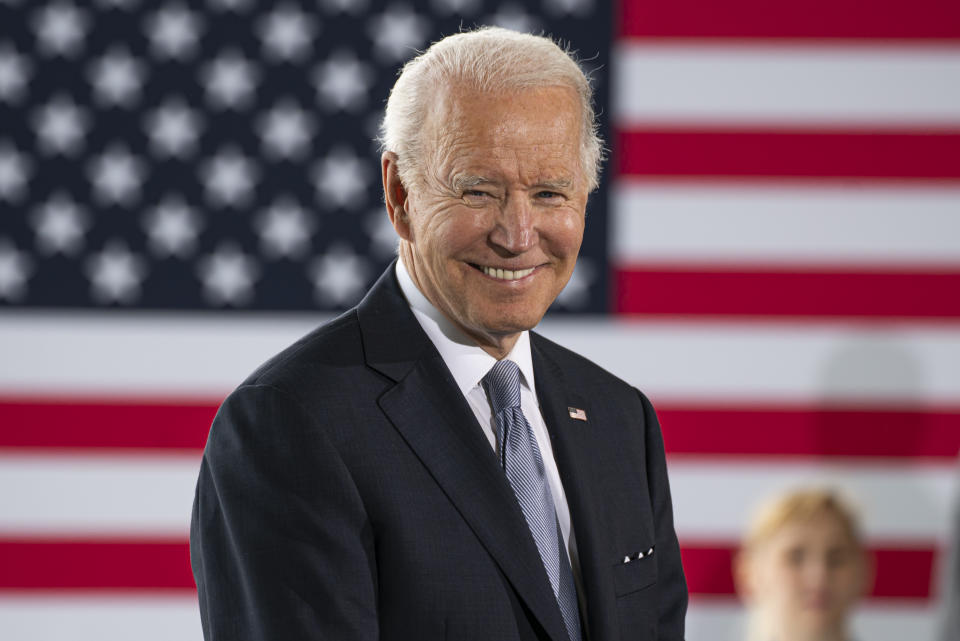 President Biden smiles while delivering remarks.