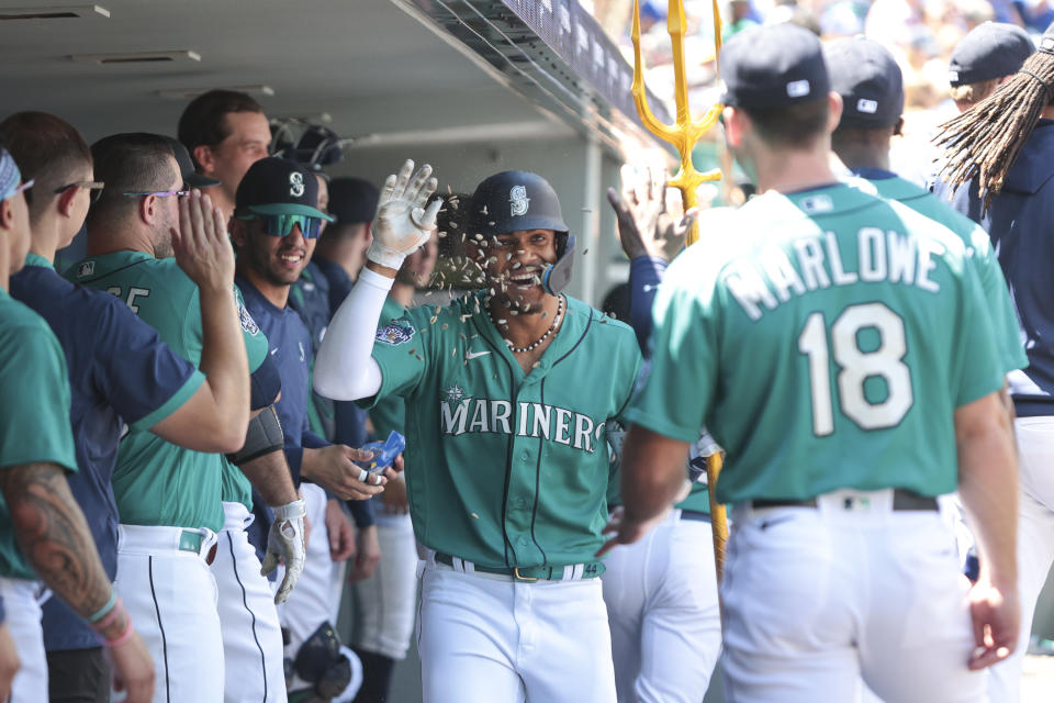 Seattle Mariners' Julio Rodriguez, center, celebrates with teammates after his solo home run during the third inning of a baseball game against the Toronto Blue Jays, Saturday, July 22, 2023, in Seattle. (AP Photo/Jason Redmond)