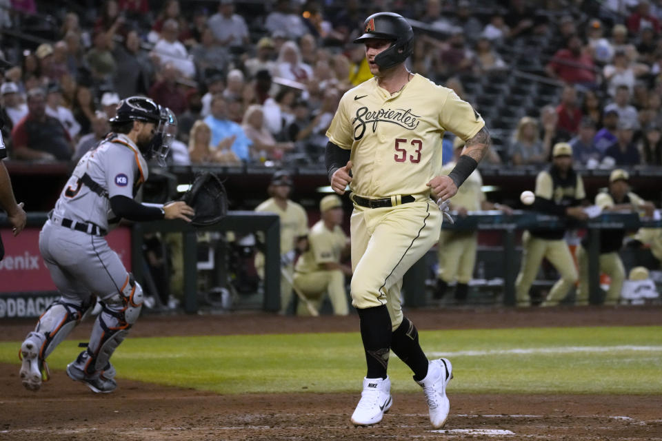 Arizona Diamondbacks' Christian Walker (53) scores a run on a sacrifice RBI fly by Josh Rojas during the fourth inning of the team's baseball game against the Detroit Tigers, Friday, June 24, 2022, in Phoenix. (AP Photo/Rick Scuteri)