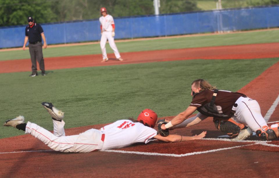 Heath's Paul Gould tags out Fredericktown's Logan Hansen at home plateon Wednesday.