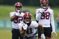 Washington Commanders running back Jonathan Williams (41) runs with the ball with running backs Jaret Patterson (32) and Reggie Bonofon (38) looking on, during practice at the team's NFL football training facility, Tuesday, May 24, 2022, in Ashburn, Va. (AP Photo/Alex Brandon)