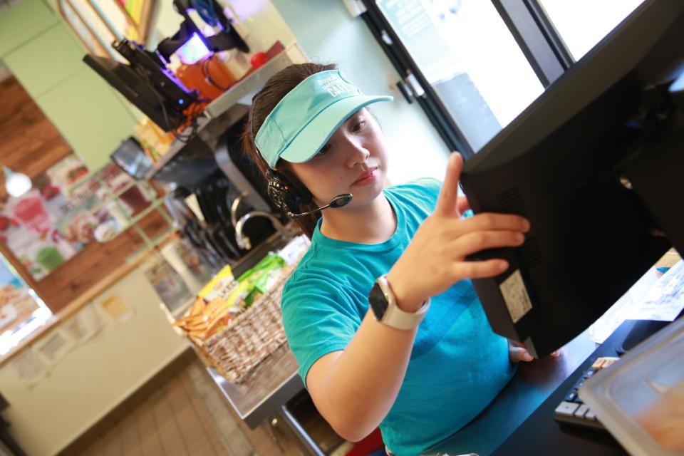 Sophia Rosales rings out a customer at the drive-thru at Tropical Smoothie Cafe, 1825 Madison St. Store owners Paul and Armi Rhodes are opening a second franchise location in September on WIlma Rudolph Road.