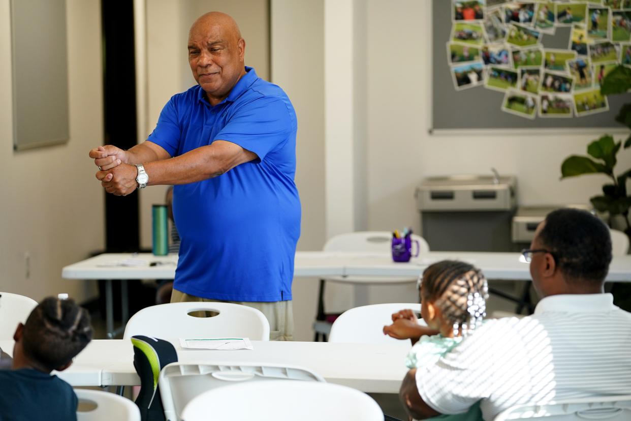 Ron Dumas teaches Reaching Out for Kids participants the different ways to grip a golf club.