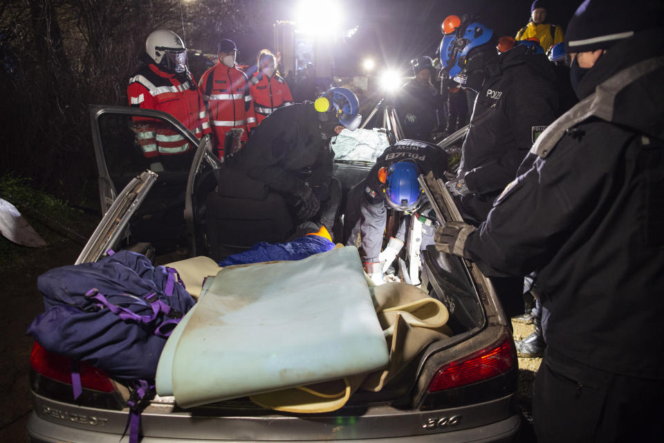 A climate activist has entrenched himself in a car, presumably chained, and is freed by police forces using a hydraulic spreader and a flex, in Luetzerath, Germany, Wednesday, Jan. 11, 2023. Environmental activists have been locked in a standoff with police who started eviction operations on Wednesday in the hamlet of Luetzerath, west of Cologne, that's due to be bulldozed for the expansion of a nearby lignite mine. (Thomas Banneyer/dpa via AP)