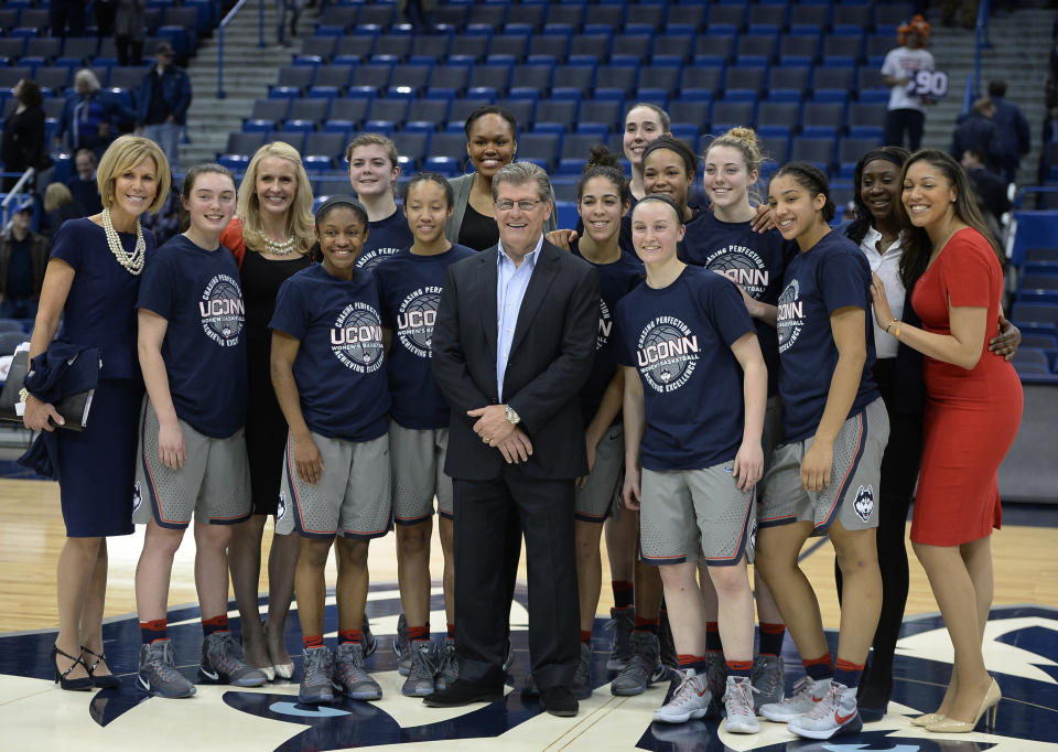 Connecticut head coach Geno Auriemma poses with his team for a photograph at the end of an NCAA college basketball game against South Florida, Tuesday, Jan. 10, 2017, in Hartford, Conn. (AP Photo/Jessica Hill)