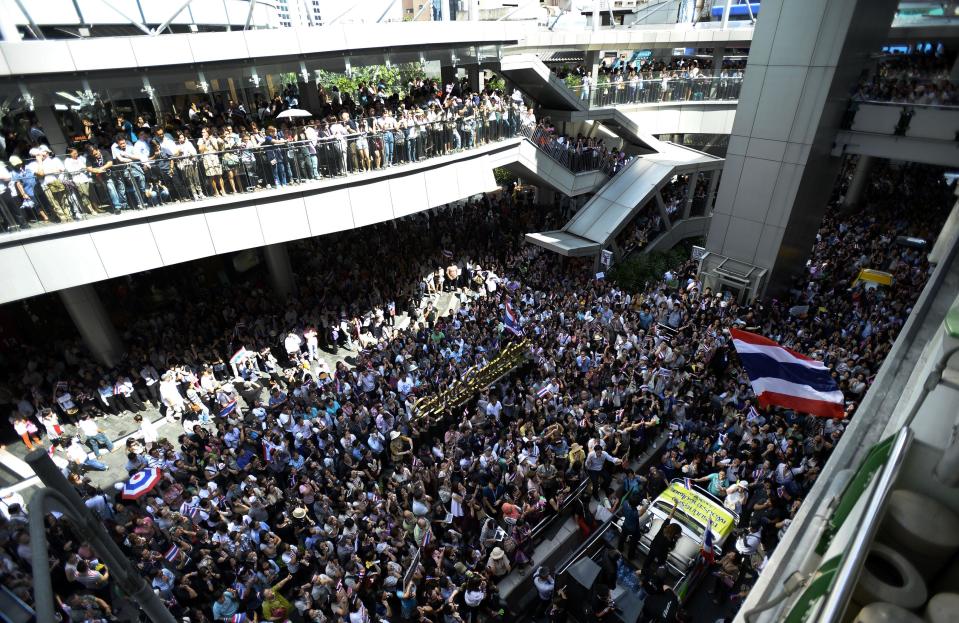 Office workers join anti-government protesters during an impromptu demonstration in central Bangkok