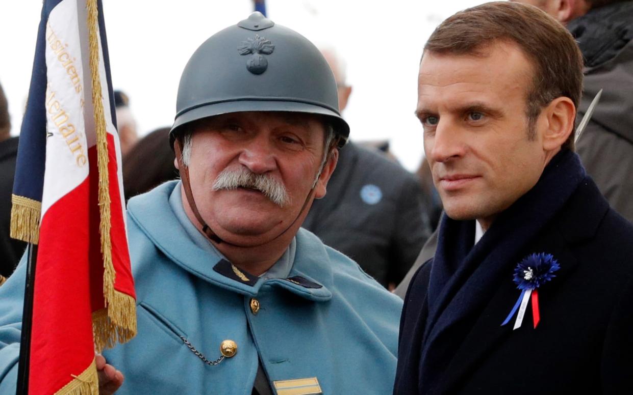 French President Emmanuel Macron, right, poses for a photo with a reenactor soldiers during a ceremony as part of the celebrations of the centenary of the First World War - Philippe Wojazer/Reuters Pool