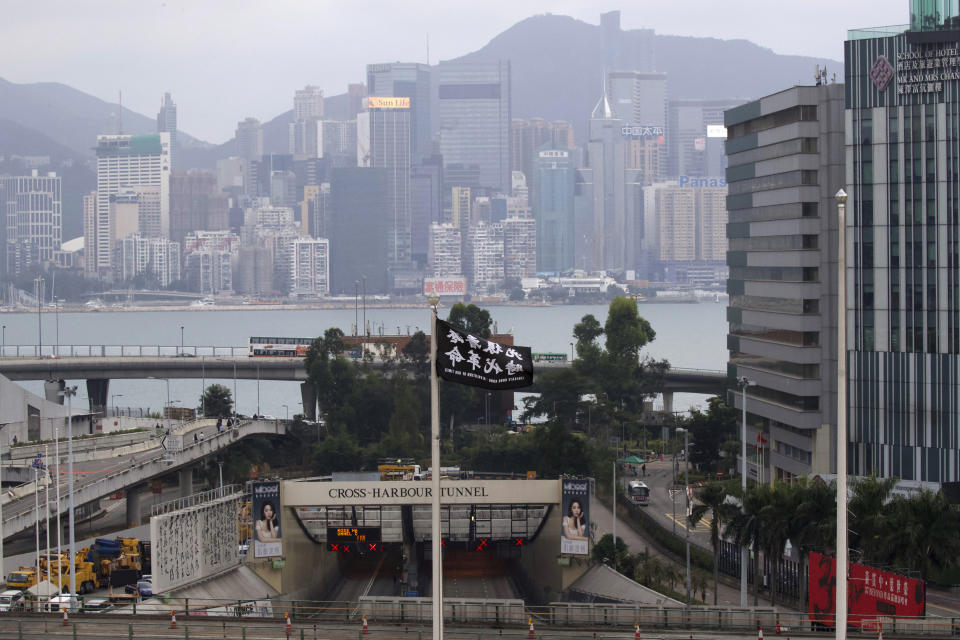 A flag reading "Liberate Hong Kong, Revolution of Our Times" flies from a flagpole at Hong Kong Polytechnic University near the Cross-Harbour Tunnel in Hong Kong, Tuesday, Nov. 26, 2019. A weeklong police siege of a university in Hong Kong may be winding down, closing one of the more violent chapters in the city's long-running anti-government protests. (AP Photo/Ng Han Guan)