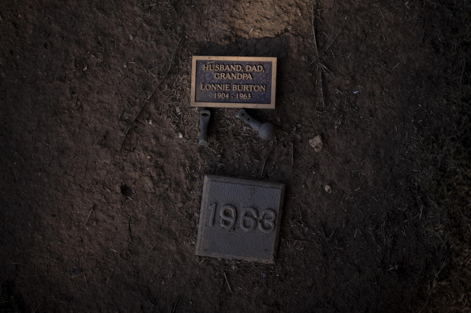 A personalized gravestone, alongside a marker indicating the year that the people died, is seen at a grave for unclaimed county residents at the Los Angeles County Cemetery in the Boyle Heights neighborhood of Los Angeles, Tuesday, Dec. 12, 2023. (AP Photo/Jae C. Hong)