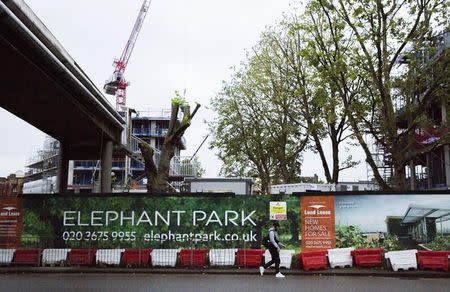 A man passes a sign for the Elephant Park building development in Elephant and Castle south London, Britain October 5, 2015. REUTERS/Neil Hall