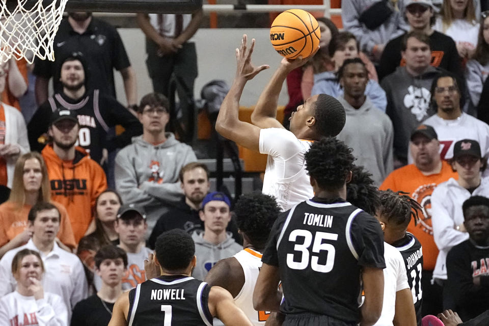 Oklahoma State guard Bryce Thompson, center, shoots in front of Kansas State guard Markquis Nowell (1) and forward Nae'Qwan Tomlin (35) in the first half of an NCAA college basketball game, Saturday, Feb. 25, 2023, in Stillwater, Okla. (AP Photo/Sue Ogrocki)