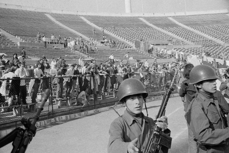 FILE - In this Sept. 1973 file photo, people who were detained following the coup against President Salvador Allende's government are taken as prisoners in the National Stadium, Santiago, Chile. Before and after those three horrifying months in 1973, the National Stadium hosted some great moments in sports. Brazil beat Czechoslovakia 3-1 in the 1962 World Cup final at the venue, and the host nation won its first major soccer title in 2015 by beating Argentina in the Copa America final. (AP Photo, File)