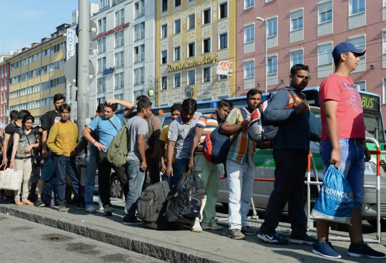 Migrants line up to catch a bus after their arrival at the main train station in Munich, southern Germany, September 1, 2015