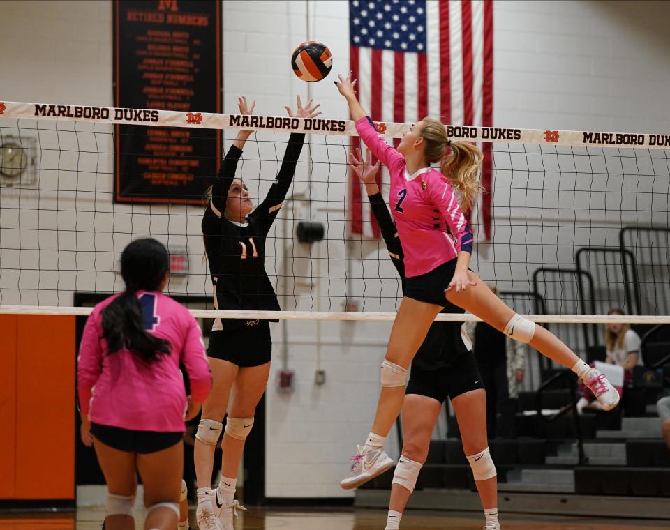 Lourdes' Molly Quirk (2) works a shot over the net as Marlboro's Madi Callahan (11) blocks during volleyball action at Marlboro High School on Tuesday, October 11, 2022.