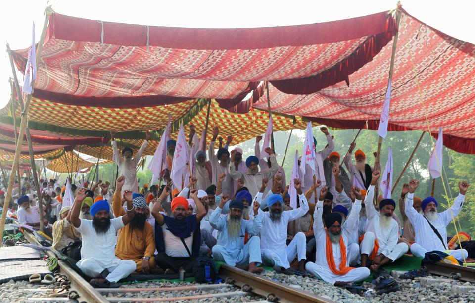 Farmers shout slogans and block train tracks during a nationwide farmers' strike following the recent passing of agriculture bills in the Lok Sabha (lower house), at Devi Dasspura village some 25 kms from Amritsar on September 25, 2020. (Photo by NARINDER NANU/AFP via Getty Images)