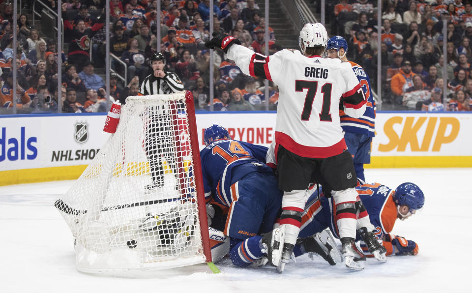 Ottawa Senators' Ridly Greig (71) celebrates as the puck goes into the net behind Edmonton Oilers goalie Stuart Skinner (74), while Mattias Ekholm (14) and Adam Erne (21) try to defend during the third period of an NHL hockey game Saturday, Jan. 6, 2024, in Edmonton, Alberta. (Jason Franson/The Canadian Press via AP)