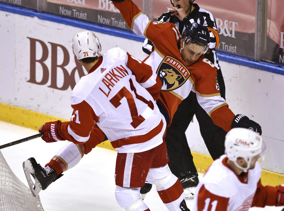 Detroit Red Wings center Dylan Larkin (71) gets called for roughing after colliding with Florida Panthers defenseman Riley Stillman (61) during the second period of an NHL hockey game Thursday, April 1, 2021, in Sunrise, Fla. (AP Photo/Jim Rassol)