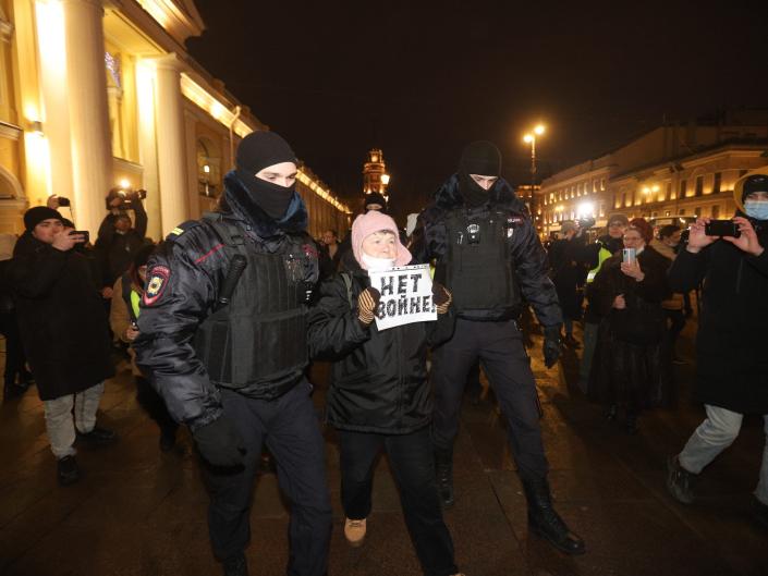 Security forces detain a woman holding a &#x00201c;No war&#x00201d; sign at an anti-war demonstration on February 24, 2022 in St. Petersburg, Russia.