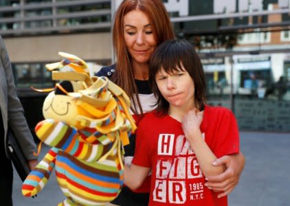 FILE PHOTO: Charlotte Caldwell, and her son Billy, stand outside the Home Office during a break in a meeting with officials to discuss how Billy can have his severe epilepsy treated with cannabis oil, which is a banned substance in Britain, in London, June 11, 2018. REUTERS/Peter Nicholls/File Photo