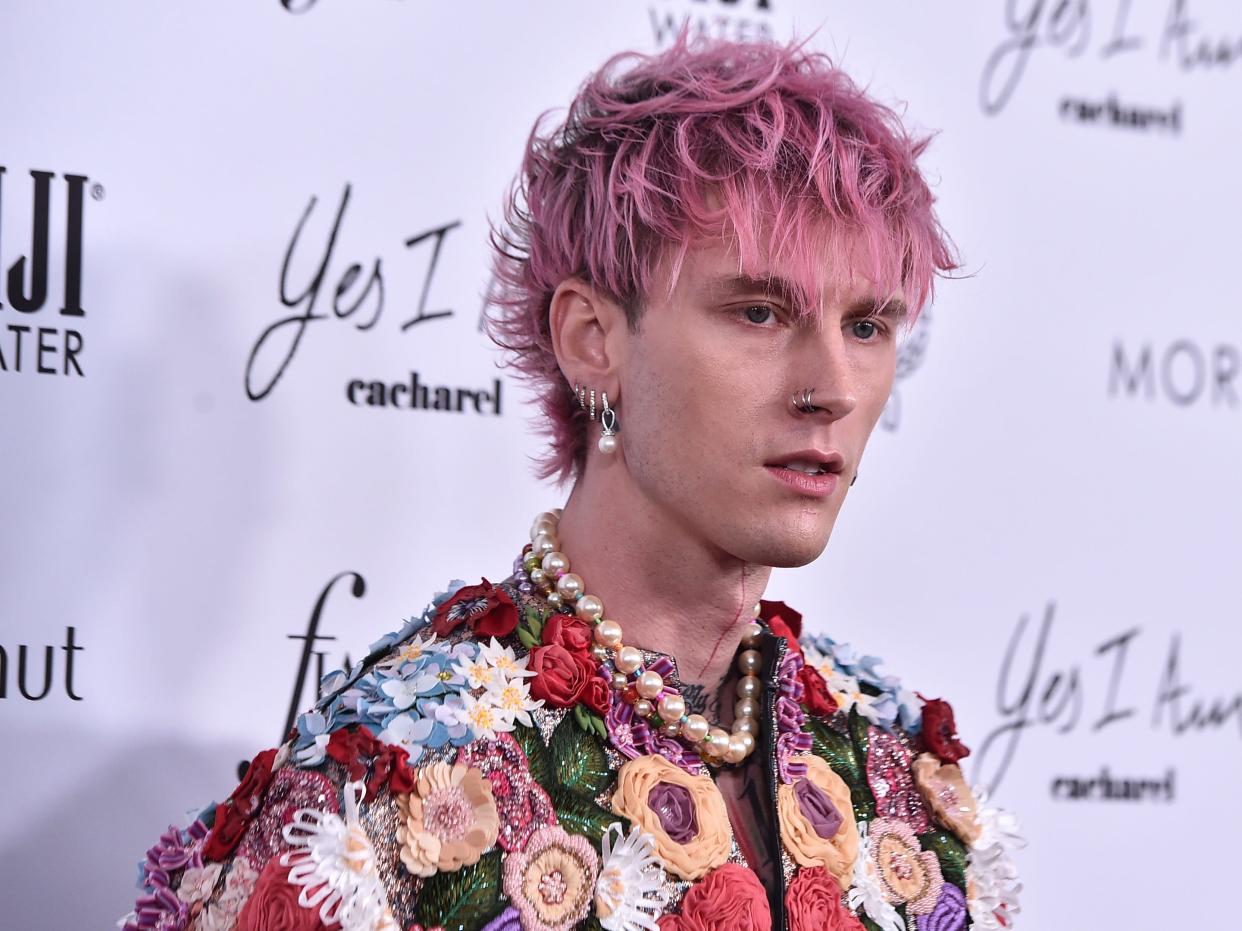 Machine Gun Kelly with pink hair and in a flower-embellished jacket.