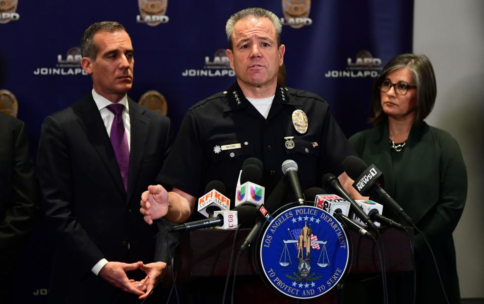 Los Angeles Mayor Eric Garcetti, left, listens as LAPD Chief Michael Moore addresses the media Tuesday about the investigation into the shooting death of rapper Nipsey Hussle and its plan to stem the recent tide of gang violence.