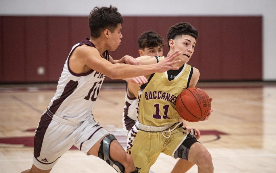 Miller's Mark Garcia pushes past London's Sean Moreno and scores during the game on Tuesday, Dec. 7, 2021 at London High School. The Buccaneers defeated the Pirates, 65-51.