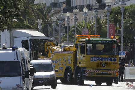 A tow truck removes the heavy truck with its windscreen covered with bullet impacts that ran into a crowd at high speed killing scores who were celebrating the Bastille Day July 14 national holiday on the Promenade des Anglais in Nice, France, July 15, 2016. REUTERS/Pascal Rossignol