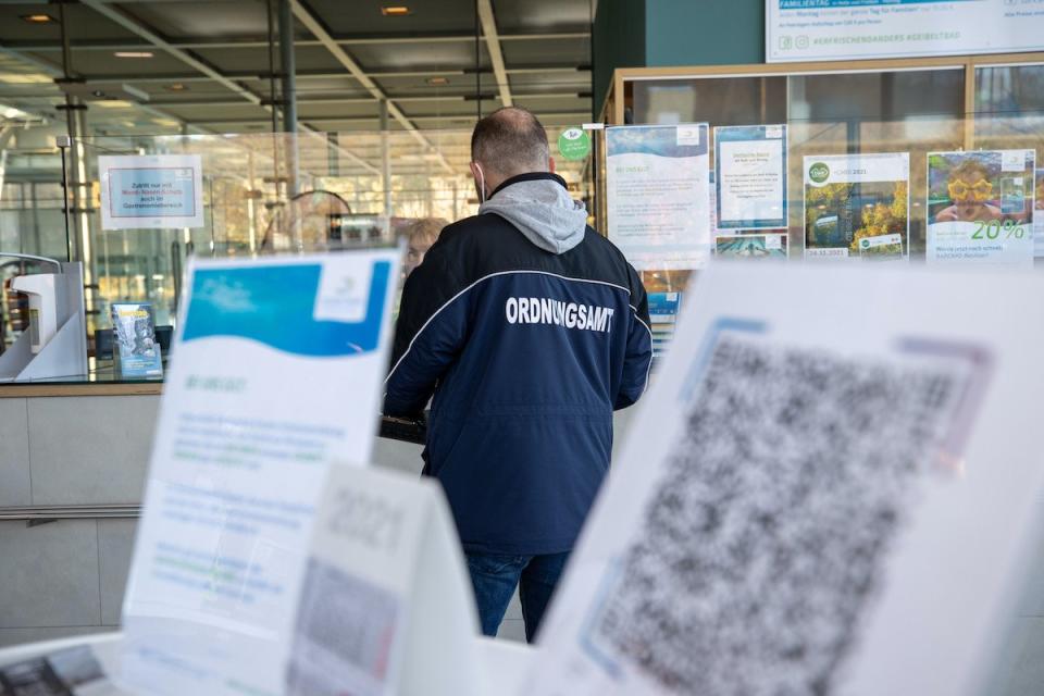 Ein Mitarbeiter vom Ordnungsamt des Landkreis Sächsische Schweiz-Osterzgebirge spricht mit einer Frau im Geibeltbad Pirna.