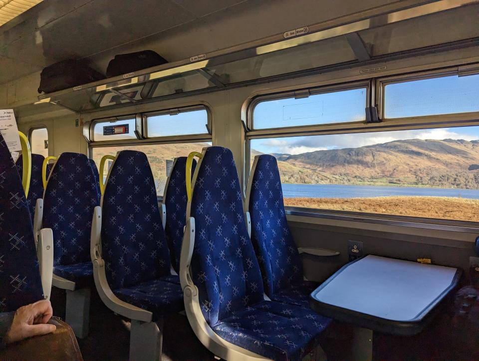 inteiror of scotrail train with blue seats and a table in front
