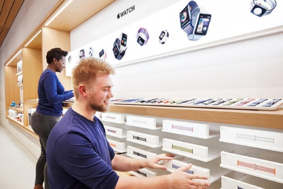 Two Apple employees straightening display bands for the Apple Watch.