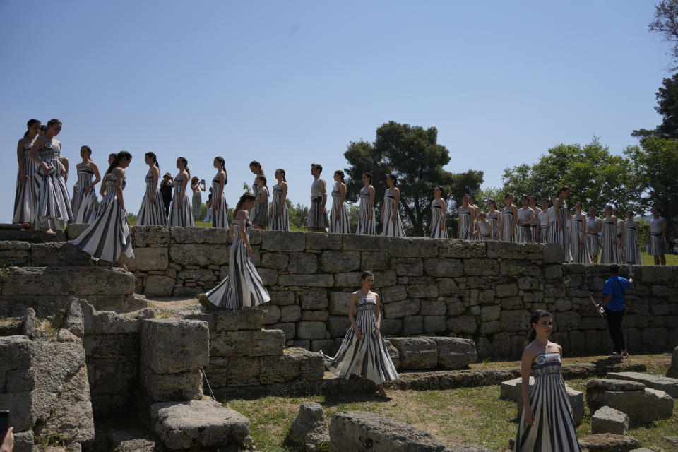 Performers, who will take part in the flame lighting ceremony for the Paris Olympics, leave after a rehearsal at Ancient Olympia site, Greece, Sunday, April 14, 2024. Every two years, a countdown to the Olympic games is launched from its ancient birthplace with a flame lighting ceremony in southern Greece at Ancient Olympia. The event is marked with a performance by dancers who assume the role of priestesses and male companions, their movement inspired by scenes on millennia-old artwork. (AP Photo/Thanassis Stavrakis)