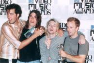 <p>The Seattle-based grunge band, Nirvana, celebrates a win at the MTV Video Music Awards in 1993. Cobain celebrates by lighting up a cigarette on the red carpet.</p>