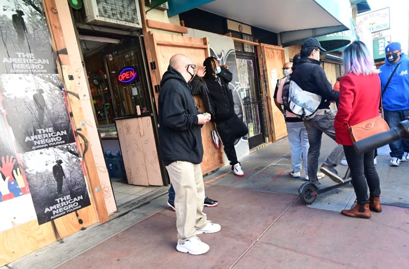 OAKLAND, CA - FEBRUARY 28, 2021 - Members of the Asians With Attitudes (AWA) confront an unruly man (second from left) outside a jewelry store as they patrol the chinatown district of Oakland, California on February 28, 2021. (Josh Edelson/for the Times)