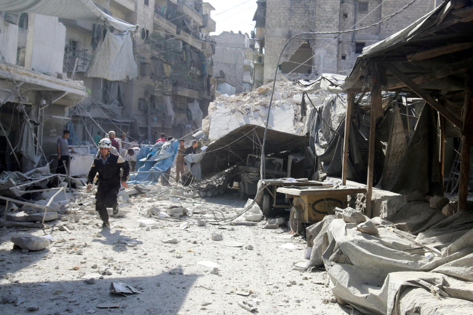 A civil defence member runs at a market hit by air strikes in Aleppo's rebel-held al-Fardous district, Syria October 12, 2016. REUTERS/Abdalrhman Ismail/files