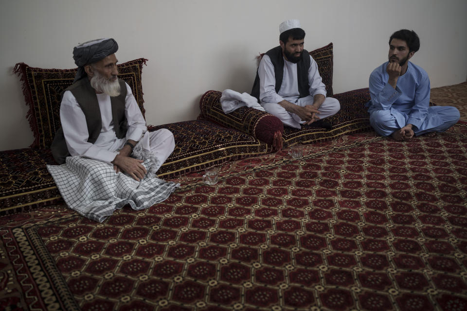 Ghulam Ghous, left, sits with his sons Ghulam Zikria, center, and Zakir Anwari, in their home in Kabul, Afghanistan, Friday, Sept. 17, 2021. Ghous lost his other son Zaki Anwari, a 17-year-old soccer player, who died after trying to board a U.S. Air Force C-17 taking off from Kabul’s International Airport last month. (AP Photo/Felipe Dana)