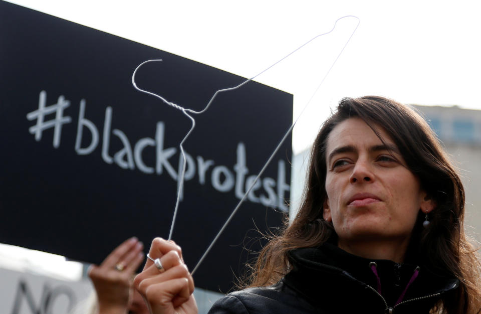 A woman protests with a clothes hanger in Brussels, the capital of the European Union.&nbsp;