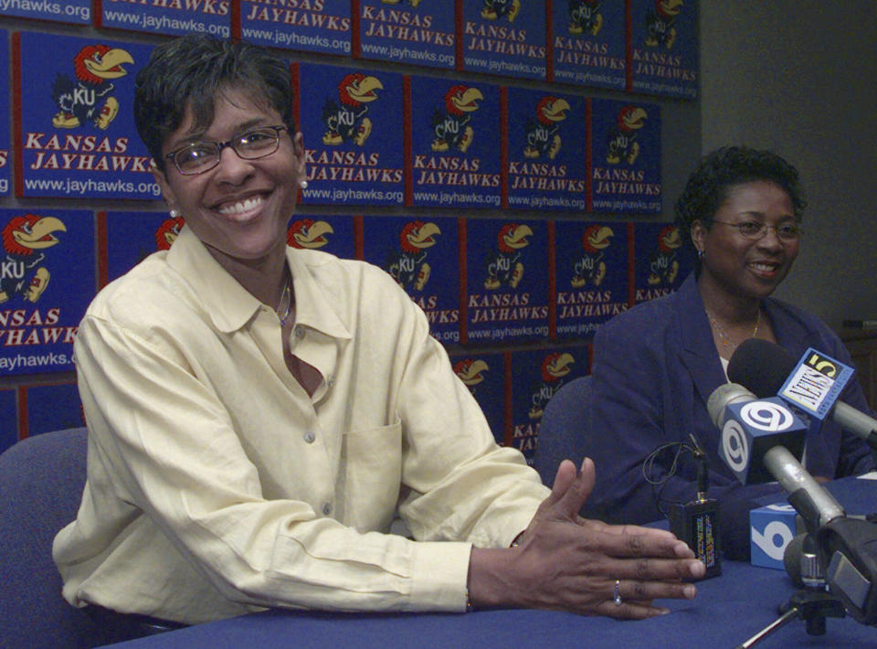 FILE - Former Kansas basketball All-American Lynette Woodard, left, announces her retirement from the WNBA at a news conference with Kansas basketball coach Marian Washington, right, Wednesday, May 26, 1999, in Lawrence, Kan. Woodard holds the women’s major college basketball record with 3,649 points from 1978-81, before the NCAA took over women’s sports from the Association for Intercollegiate Athletics for Women. (AP Photo/Orlin Wagner, File)
