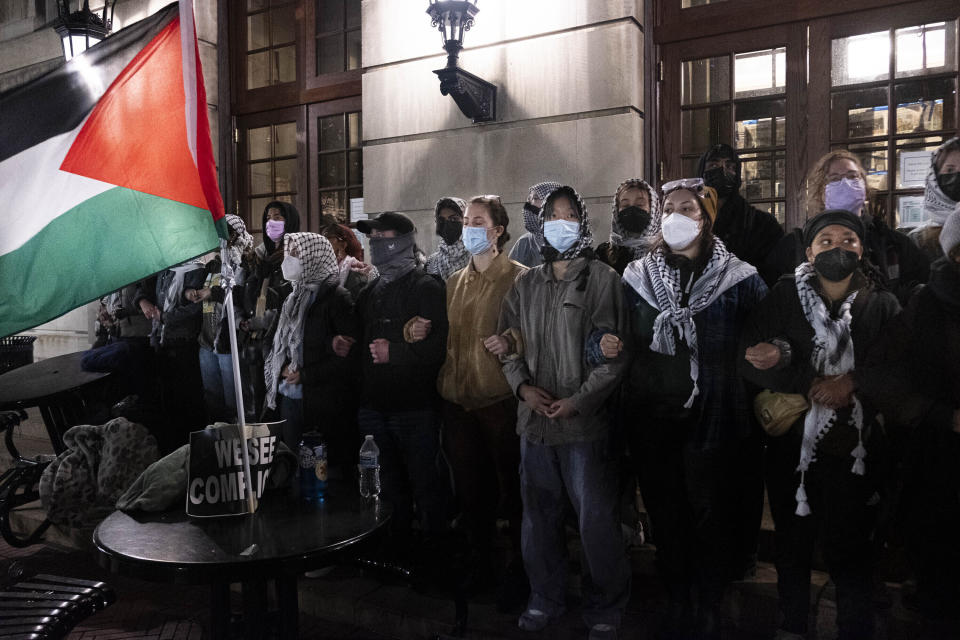 Estudiantes propalestinos se agarran de los brazos y corean consignas mientras se preparan para la incursión de policías neoyorquinos en el campus después de que la rectora de la Universidad de Columbia, Minouche Shafik, pidiera a la policía que desmantelara los campamentos y expulsara a las personas del Hamilton Hall, el martes 30 de abril de 2024, en Nueva York. (Seyma Bayram vía AP)